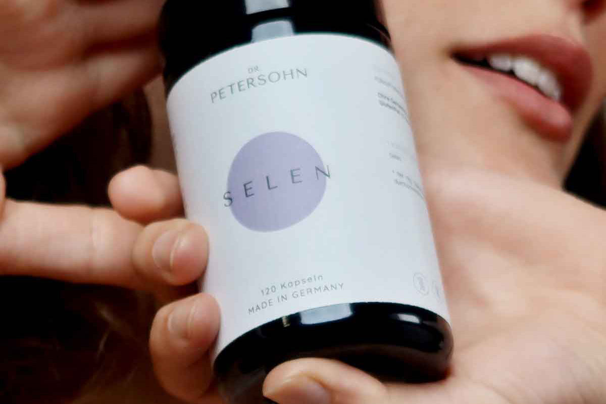 Junge Frau hält das Produkt von Dr. Petersohn vor ihrem Gesicht.
